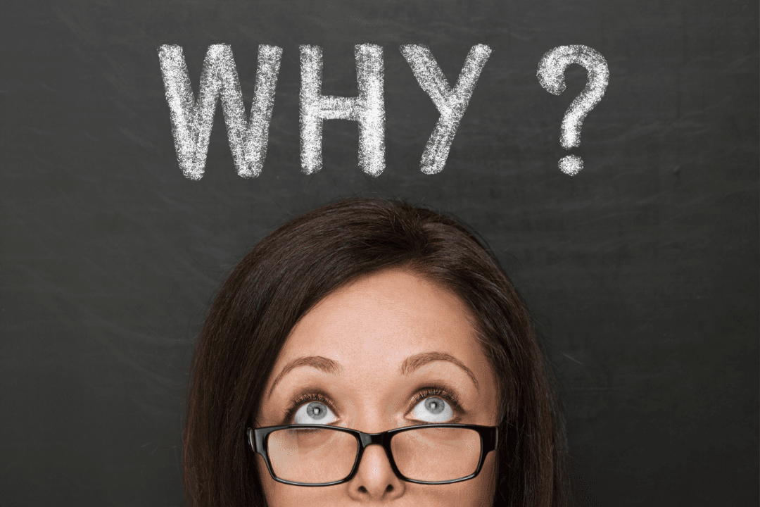 A girl staring at a blackboard above which contains the word: Why?