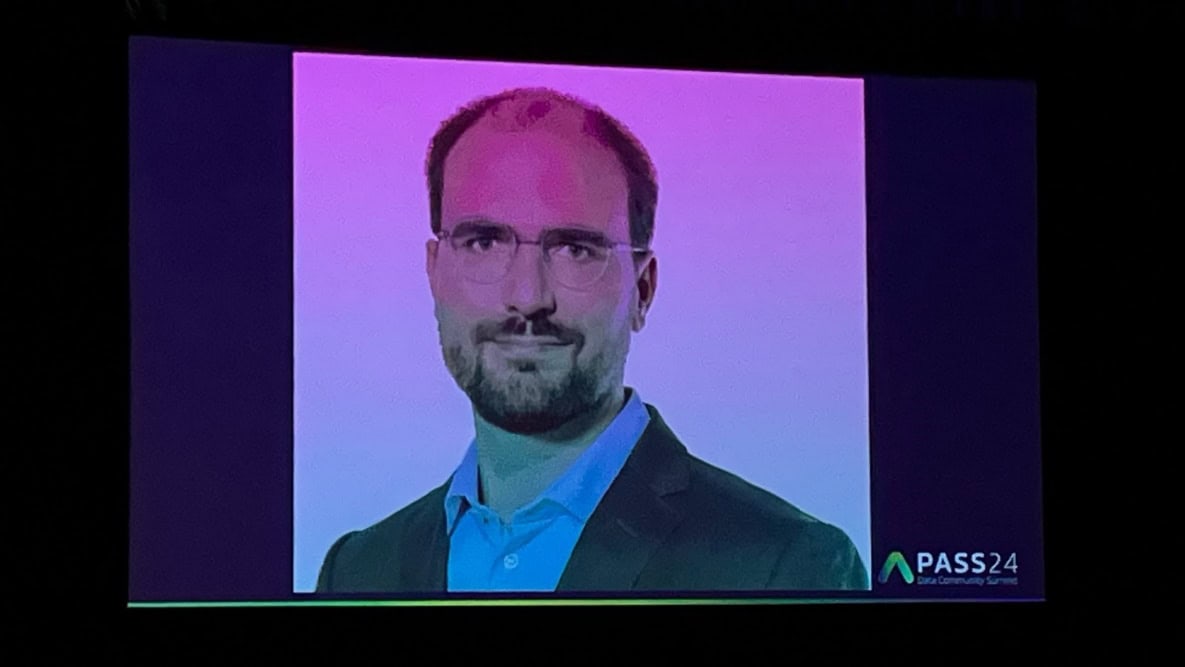 A person wearing glasses and a suit

Description automatically generated