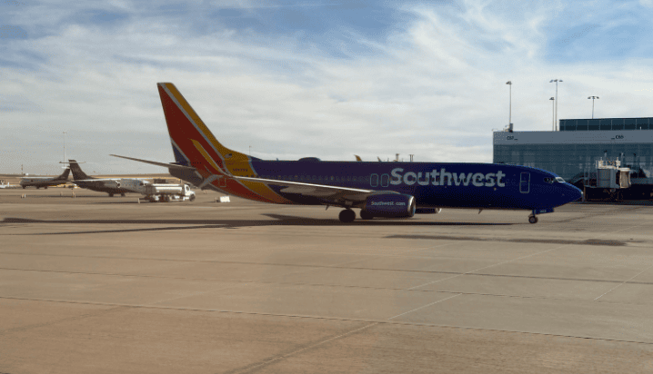 A blue and yellow airplane on a runway Description automatically generated