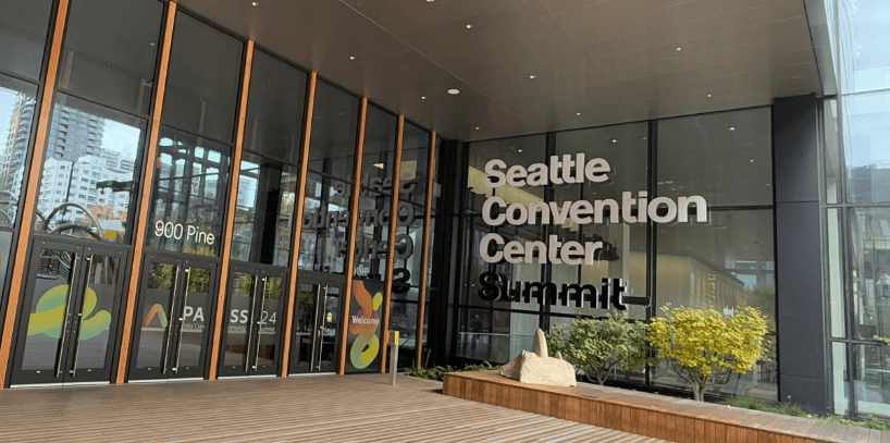 A building with glass walls and a sign
Description automatically generated