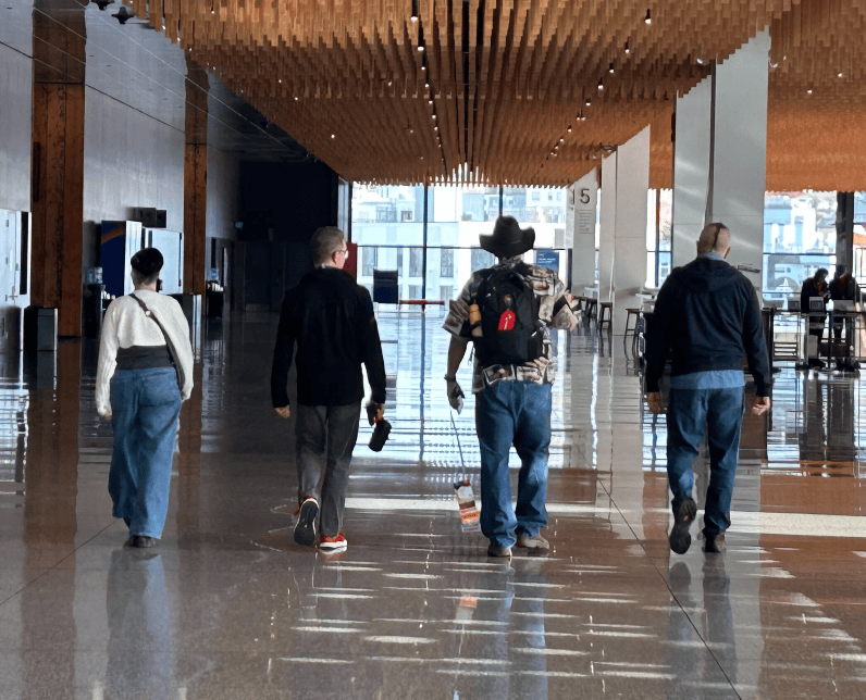 A group of people walking in a hallway
Description automatically generated