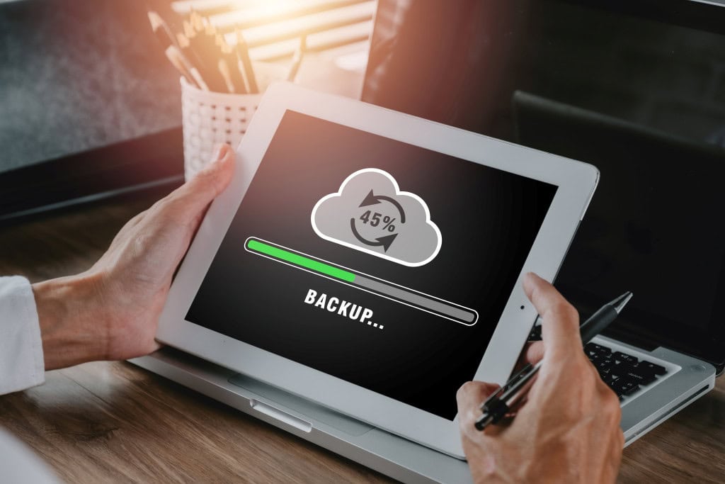 An image showing a tablet device being backed up.